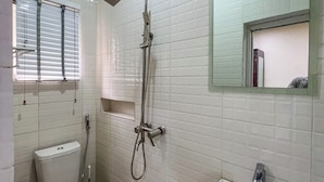 A bathroom with a toilet, a sink, and a shower. - Kpees Apartment (Abuja)