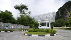 A modern building with a glass facade, surrounded by greenery and a stone wall with the name "Haven". - Ipoh All Suite Resort, Jalan Haven Ipoh (Kinta)