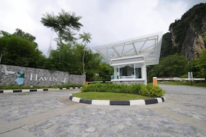 A modern building with a glass facade, surrounded by a landscaped area with a stone pathway and a sign reading 'The Haven'. - Ipoh All Suite Resort, Jalan Haven Ipoh (Kinta)