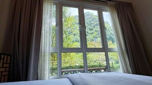 A room with a large window, a bed, and a view of greenery outside. - Ipoh All Suite Resort, Jalan Haven Ipoh (Kinta)