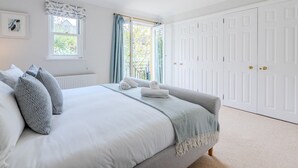 Un dormitorio con cama, ventana, radiador y armario.