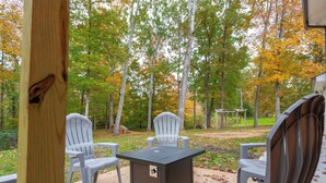 An outdoor patio area with a table and four chairs, surrounded by trees with autumn foliage. - Beautiful Getaway! 16+ppl and close to Chattanooga! (Ringgold)