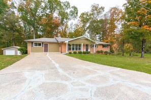 A single-story house with a front garage, a driveway, and a lawn.