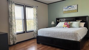 A bedroom with a bed, curtains, a wall clock, and a painting. - Spacious 3BR Home + Barn Theater in the Country Between Dallas & Houston (Rice)