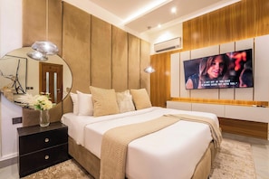 A modern bedroom with a bed, bedside tables, a TV, and a mirror. - Top-Notch Apartment (Abuja)