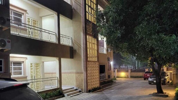 A multi-story building with a paved driveway and a parked car. - Top-Notch Suites and Apartment (Abuja)