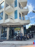 Entrada de un hotel con un cartel que dice "ROYALSARANDA HOTEL" y un hombre de pie frente a él.