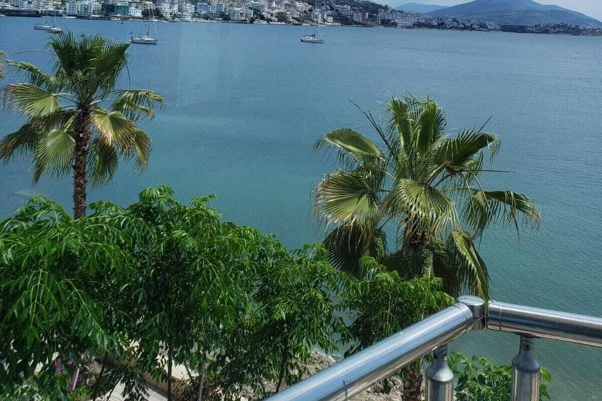 Un paisaje urbano costero con vista al mar, edificios y una colina al fondo.