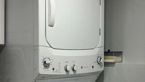 Una lavanderia piccola e moderna, con lavatrice e asciugatrice a carica frontale.