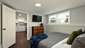 Una camera da letto con un letto, una cassettiera, una TV e una finestra.