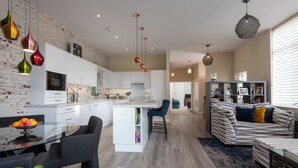 A modern kitchen with white cabinets, a central island, and pendant lighting. - Countryside Escape for Friends and Family (Haslemere)