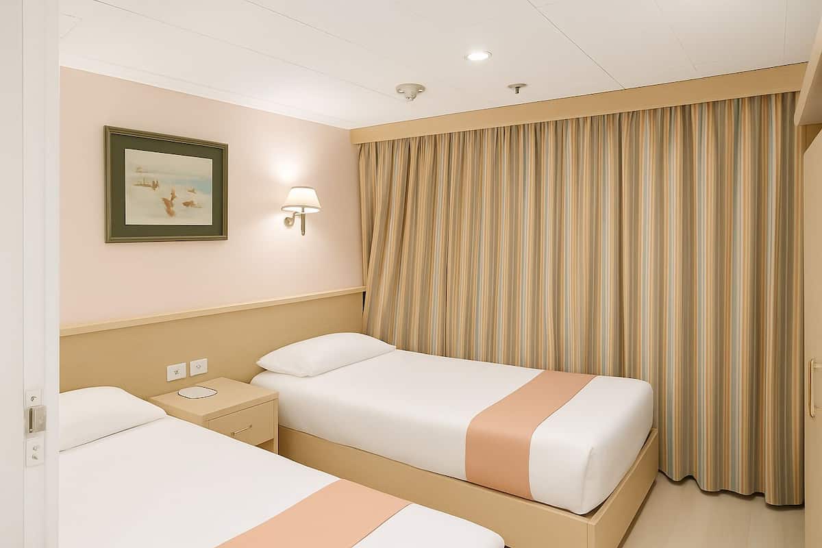 A hotel room with two beds, a nightstand, a wall-mounted lamp, and a striped curtain.