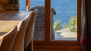 A wooden interior with a view of mountains through a glass door. - Chalet Chanterelle - Cosy and mountainy (Haute-Nendaz)