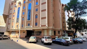 A multi-story hotel with a prominent arched entrance and large windows. - Alabraj Hafawa Hotel Company (Makkah)