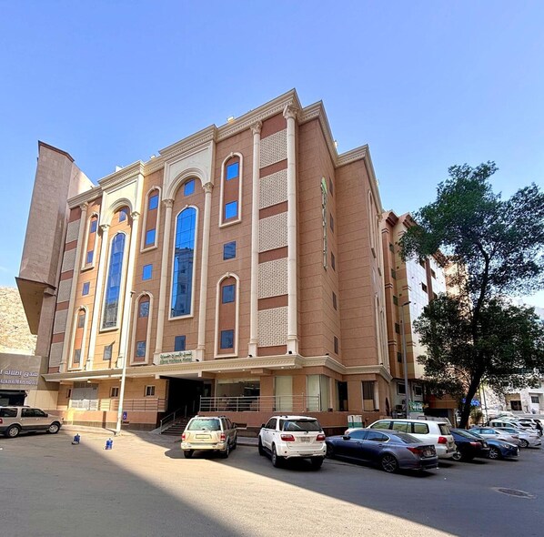 A multi-story hotel with a prominent arched entrance and large windows. - Alabraj Hafawa Hotel Company (Makkah)