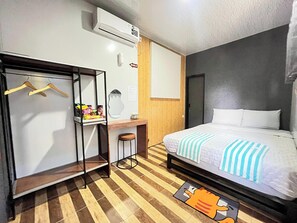 A hotel room with a bed, a desk, a wardrobe, and an air conditioning unit. - Ijen Menjangan View (Banyuwangi)