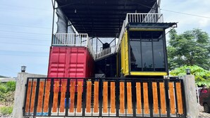 A structure made of shipping containers with a metal roof and a gated entrance. - Ijen Menjangan View (Banyuwangi)