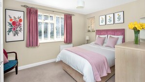 A bedroom with a bed, a chair, a dresser, and a window with curtains. - Countryside Retreat on Surrey/Hampshire Border (Haslemere)