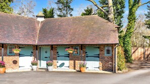 A brick building with a tiled roof, two doors with shutters, and potted plants in front. - Countryside Retreat on Surrey/Hampshire Border (Haslemere)