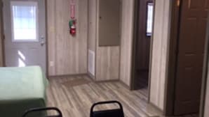 Una habitación pequeña con una mesa verde, dos sillas, una puerta y un extintor.