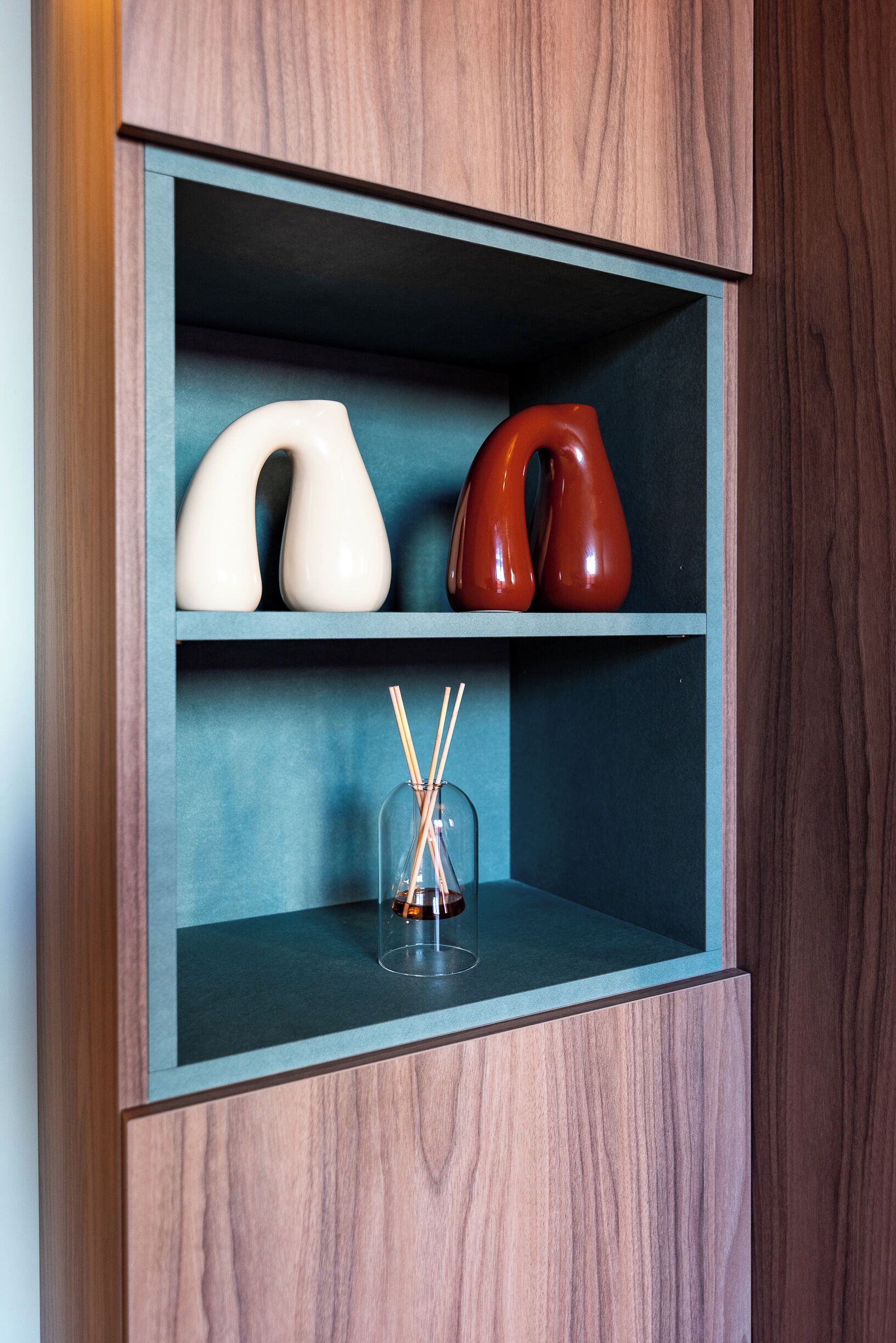Un mueble de madera con dos estantes, cada uno con objetos decorativos.