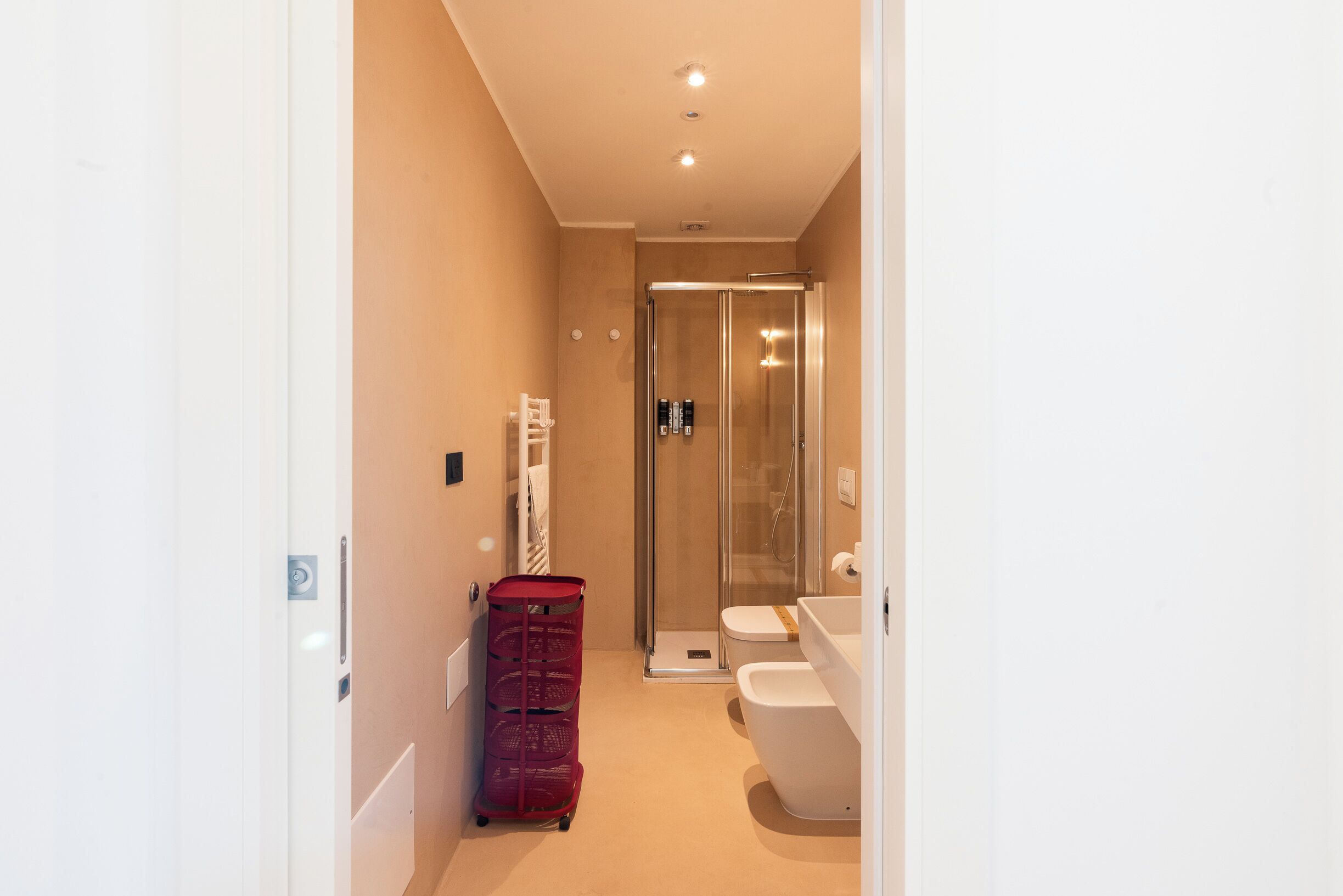 Une salle de bain moderne avec une douche à parois de verre, des toilettes blanches et un lavabo.