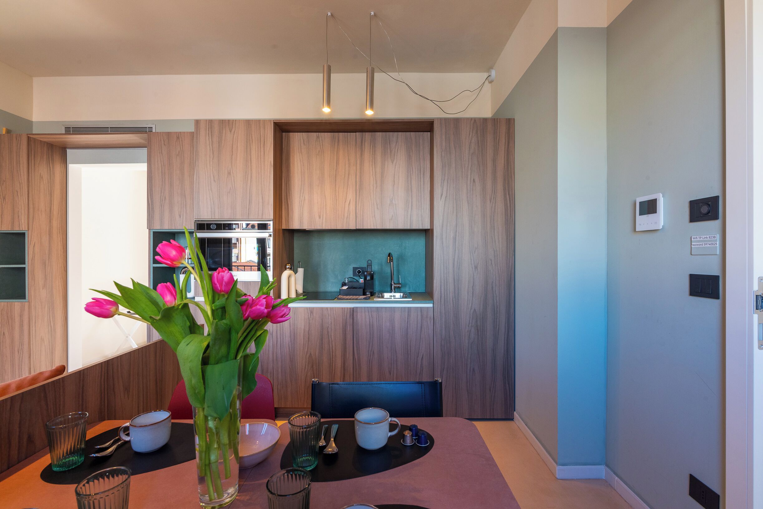 Una cocina moderna con armarios de madera, horno empotrado y una ventana sobre la encimera.
