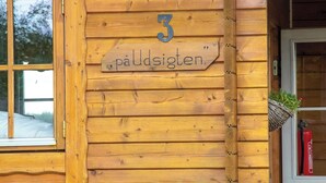 A wooden cabin with a sign reading "3 påudsigtens" and a window with a view of trees. - Blokhus with spectacular views in Jutland's nature area (Nørre Snede)