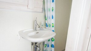 A bathroom with a white sink, toilet, and shower curtain. - Blokhus with spectacular views in Jutland's nature area (Nørre Snede)