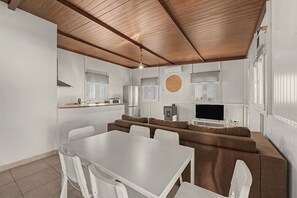 A modern kitchen with a dining area, white walls, and a wooden ceiling. - Holiday Home 'El Encanto De Ronda' with Mountain View, Private Pool and Wi-Fi (Ronda)