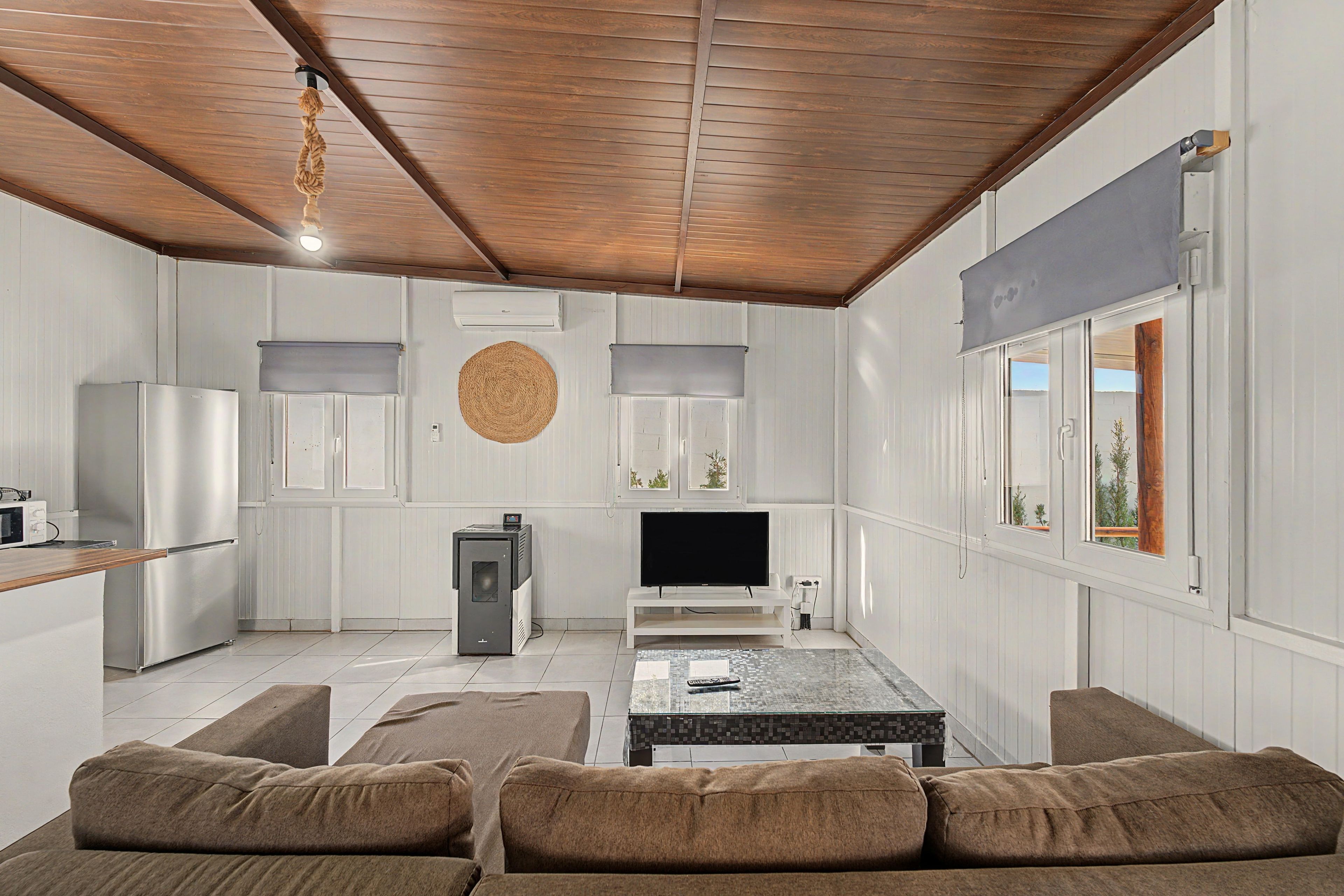 Un espacio habitable compacto con kitchenette, un televisor de pantalla plana, comedor y zona de estar.