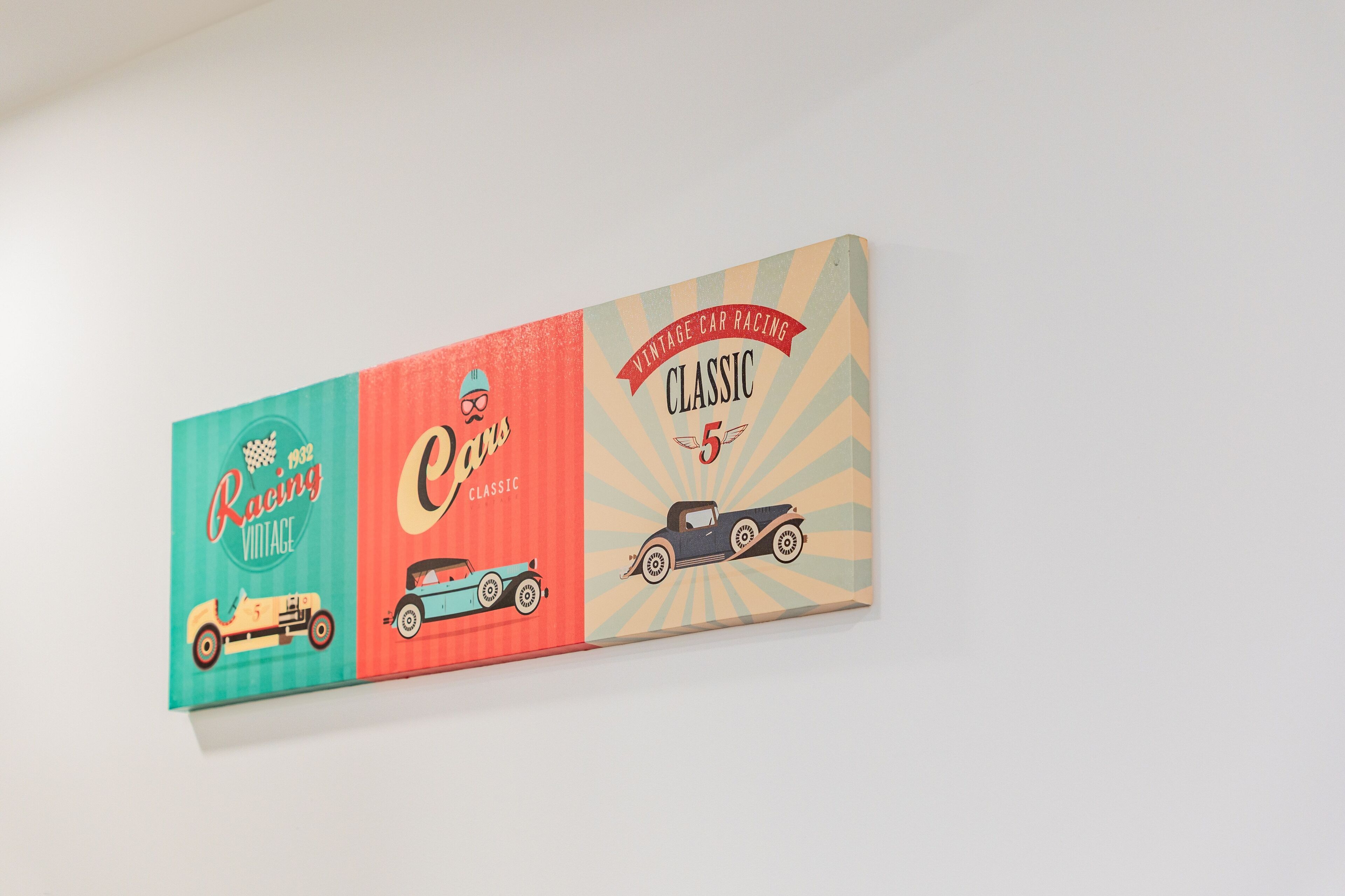 A vintage car racing themed wall art with illustrations of classic cars and racing numbers.