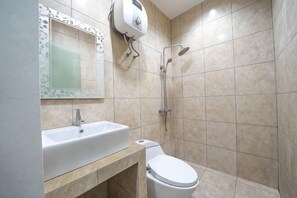 Un baño con lavamanos, inodoro y ducha.