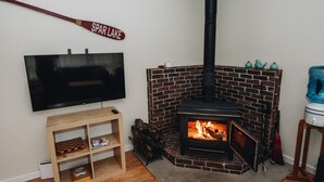 Un salon avec une cheminée en briques, un téléviseur et une enseigne sur laquelle on peut lire « SPAR LAKE ».