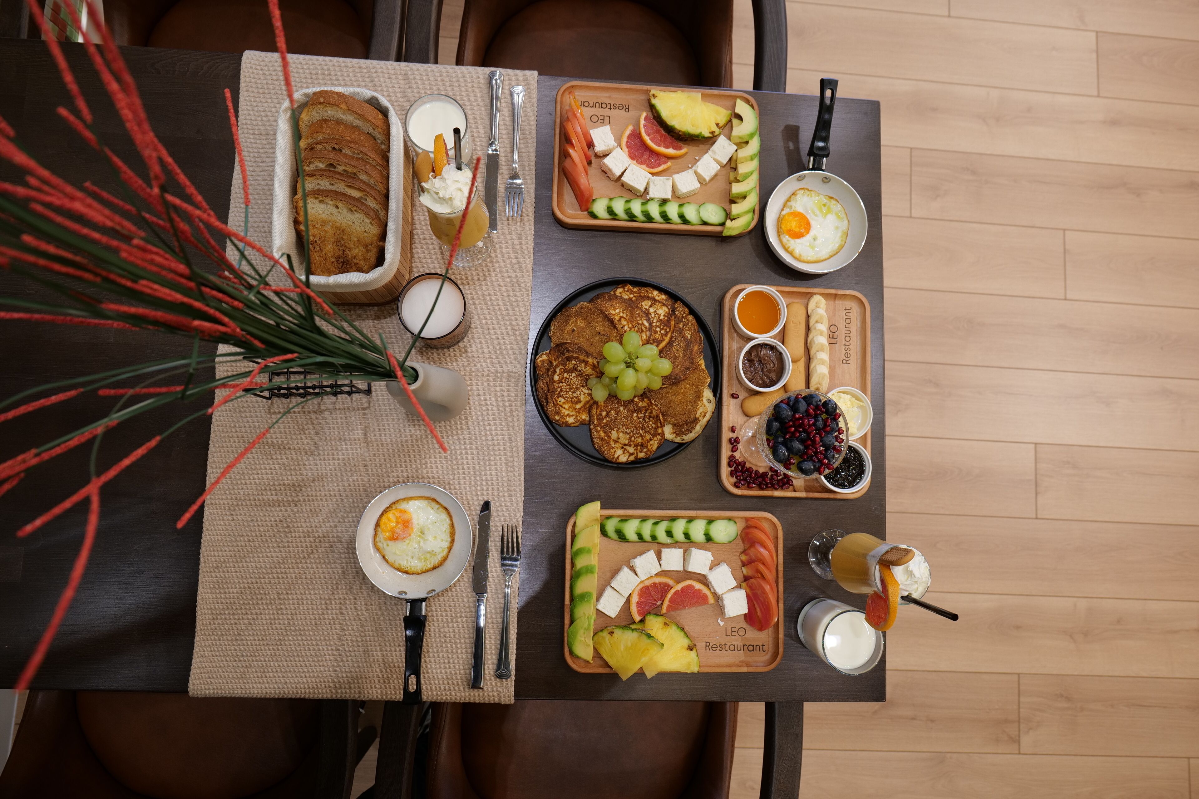 A breakfast setting with a variety of food items and drinks on a wooden table.