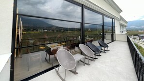 A balcony with a view of the landscape, featuring a table and chairs. - Leo Hotel (Shtiqën)