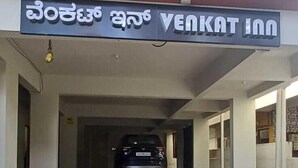 The entrance of Venkat Inn with a tiled pavement and a parked car inside. - VENKAT INN (Bengaluru)