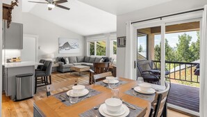 Un espace de vie moderne comprenant un coin repas, une cuisine et un balcon avec vue.