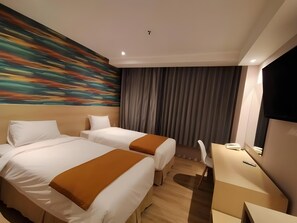 A hotel room with two beds, a desk, a chair, a television, and a large abstract painting on the wall. - Lereng Bromo Hotel (Tosari)