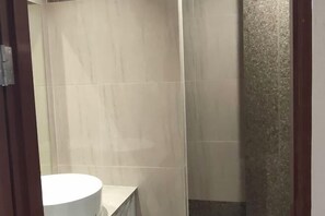 Une salle de bain avec un lavabo blanc et des murs carrelés.