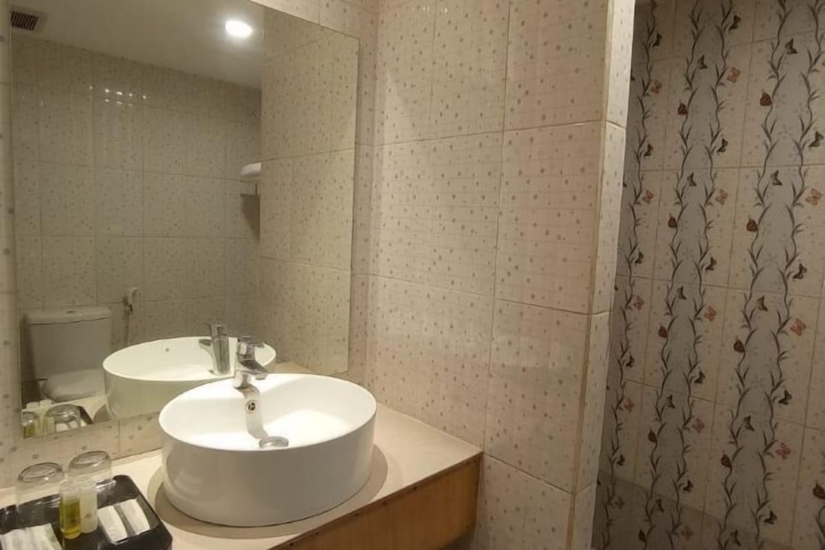 Un baño con dos lavamanos, un espejo y una ducha.