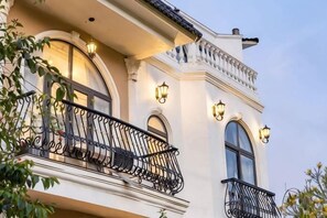 Un bâtiment doté d’un balcon, de grandes fenêtres et d’un éclairage décoratif.