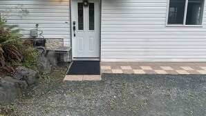 A white house with a front door, a small porch, and a window. - Beautiful 3-bedroom apartment in Lindell Beach (Lindell Beach)