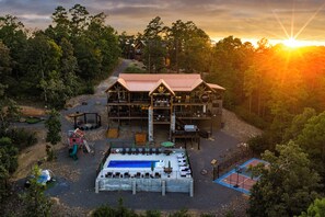 A lodge with a large deck, outdoor seating, and a pool.