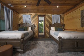 A room with two wooden beds, a carpeted floor, and a door leading outside.