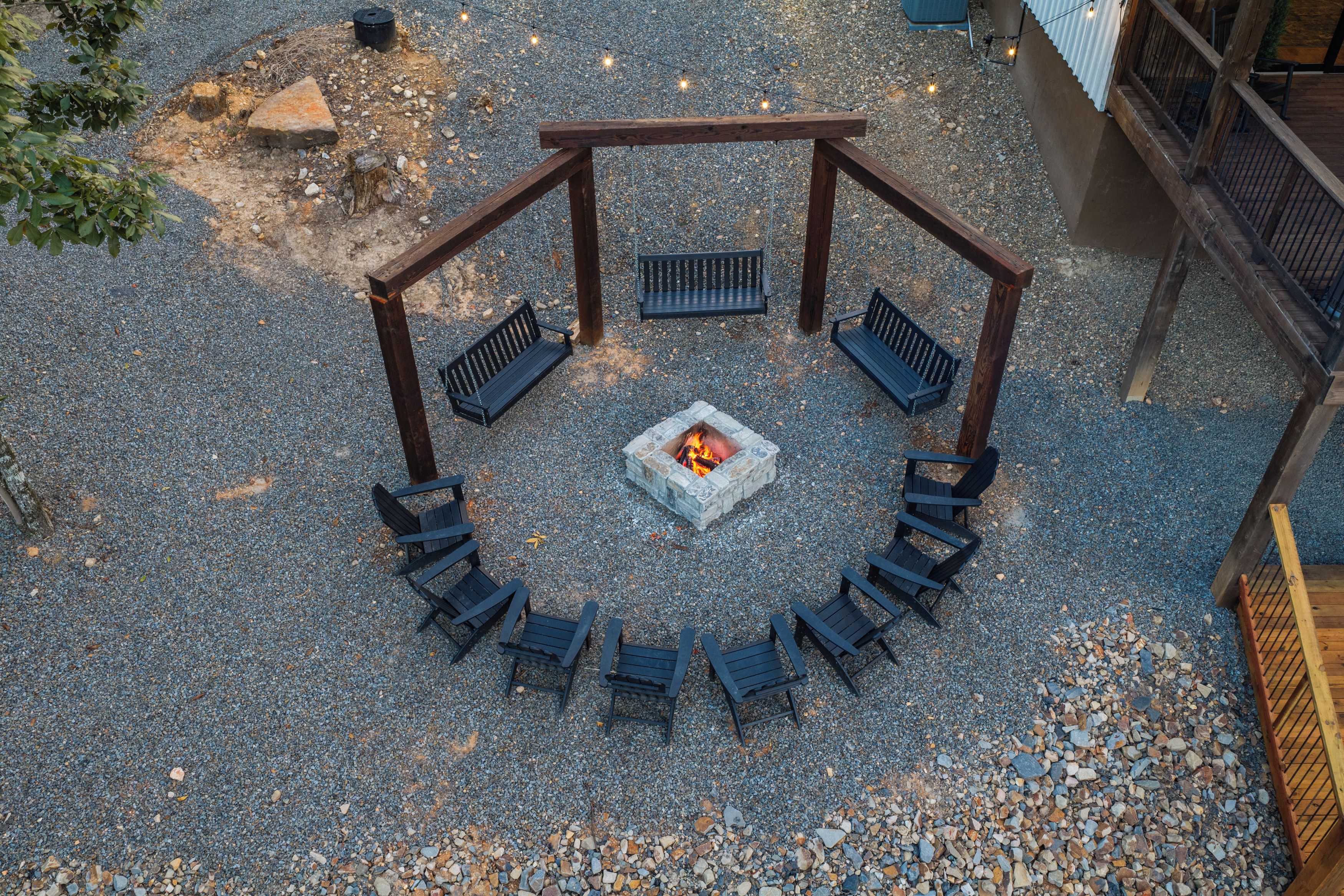 Un área de estar al aire libre con una chimenea y bancos dispuestos en semicírculo.
