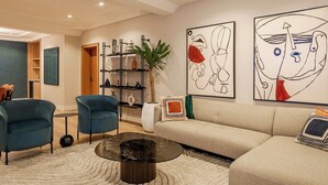 A modern living room with a sofa, two armchairs, a coffee table, and abstract art on the walls. - Twin Heart Residence (Abuja)