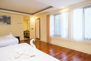 A hotel room with two beds, a wooden floor, a large window with sheer curtains, and a painting on the wall. - The Lavana Villa Gajah Jimbaran (Bali)