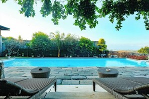 A swimming pool with lounge chairs and a stone patio. - The Lavana Villa Gajah Jimbaran (Bali)