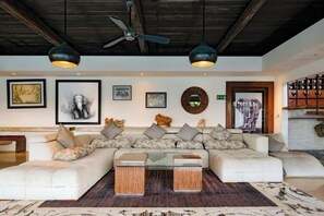 A modern living room with a sectional sofa, a coffee table, and artwork on the walls. - The Lavana Villa Gajah Jimbaran (Bali)